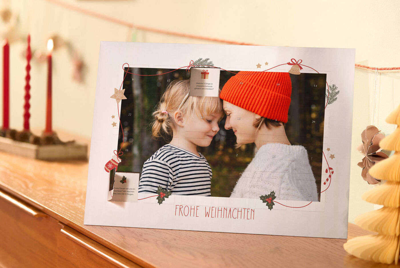 CEWE Adventskalender mit persönlichem Foto in weihnachtlicher Umgebung, zwei Türchen sind geöffnet und weihnachtlich Illustrationen mit Text